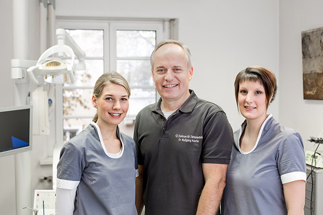 Zahnarzt Dr. Wolfgang Kaefer mit zwei Assistentinnen.